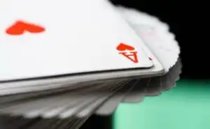 Closeup of a fanned out deck of cards with the ace of hearts on top