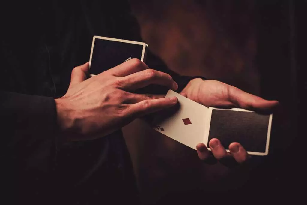 Shot of a man's hands holding a deck of cards and performing cardistry maneuvers with it